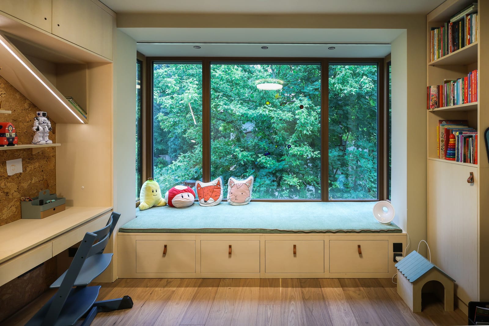 Custom window bench framing the garden in the kid's room